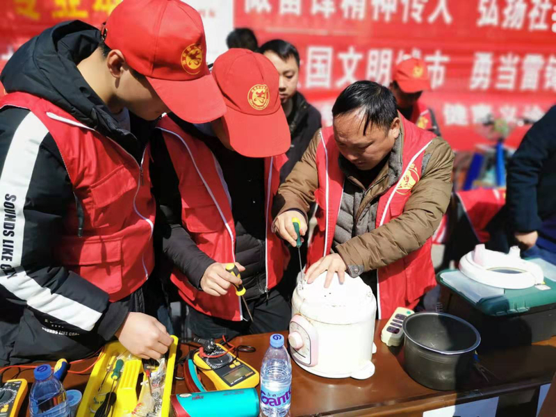2 志愿者在江老师指导下修理电饭煲.jpg